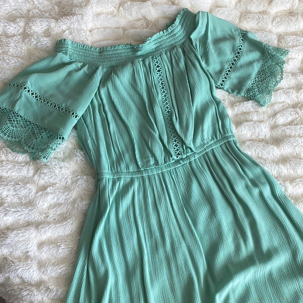 A mint green mid length, off the shoulder dress
